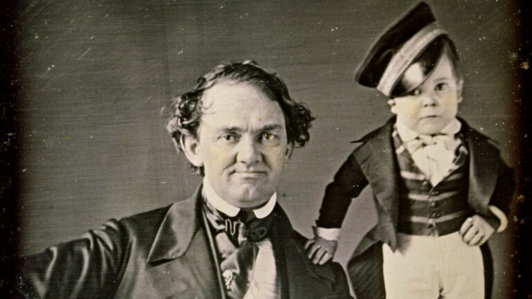 Daguerréotype ancien de P.T. Barnum, homme aux cheveux bouclés en costume sombre, à côté du petit Charles Stratton, dit Tom Pouce, en uniforme
